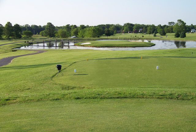 A golf course with a pond in the middle of it