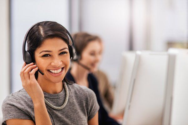 A young woman at the office is happy to answer a customer's call