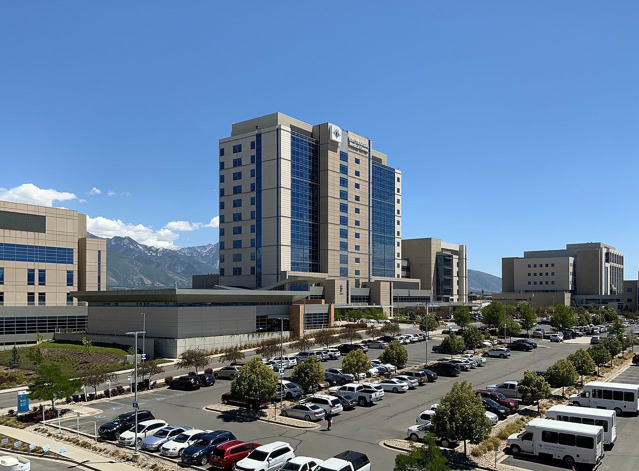 A large building with a lot of cars parked in front of it.