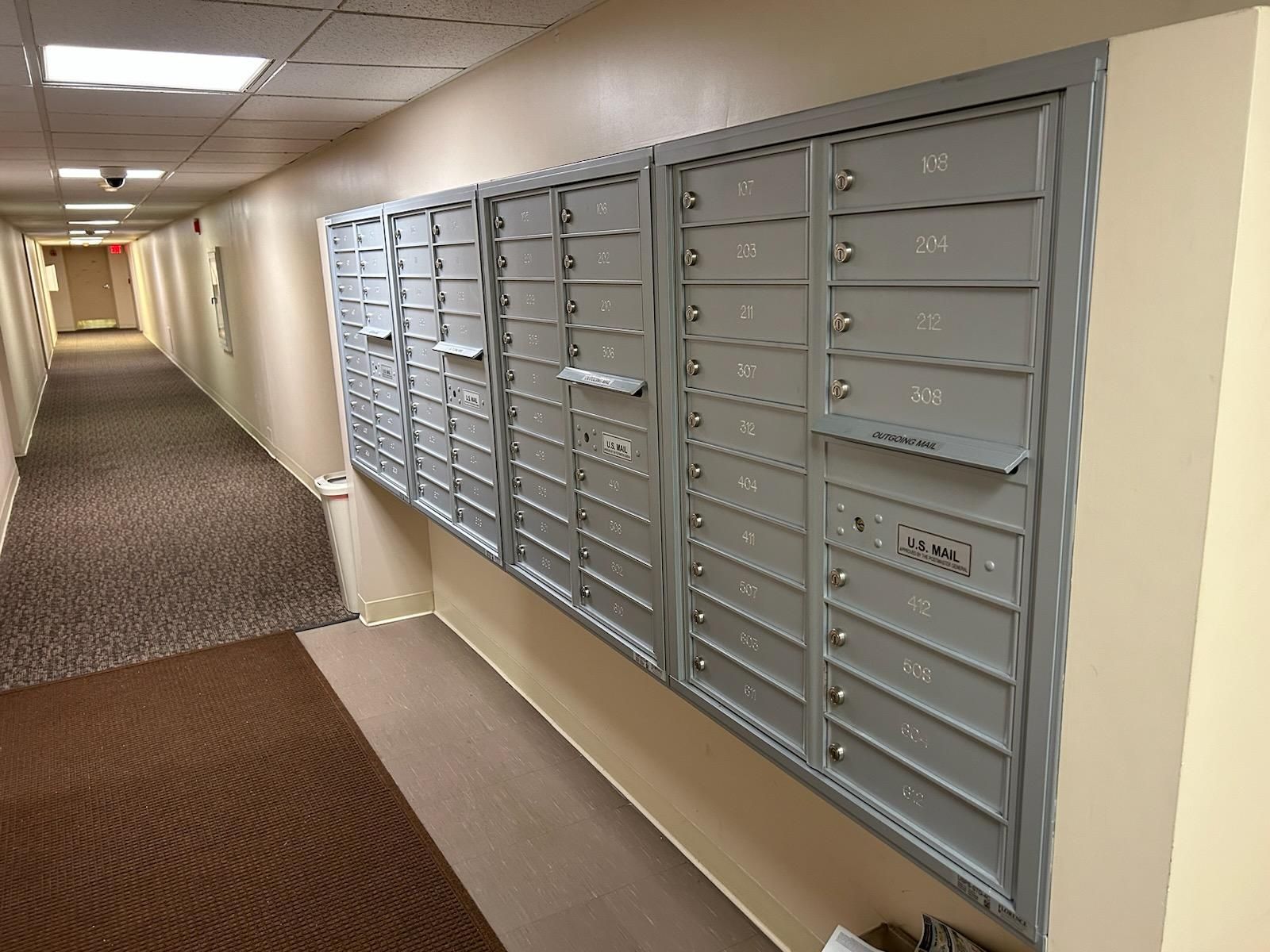 A hallway with a row of mailboxes on the wall