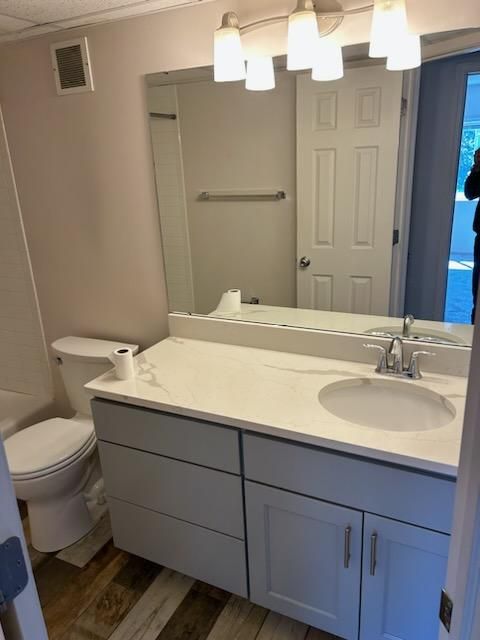 A bathroom with a toilet a sink and a mirror