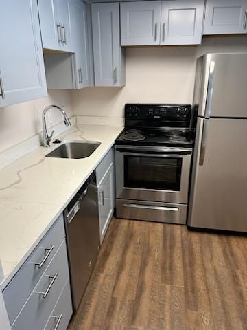 A kitchen with a stove , refrigerator , sink and dishwasher.