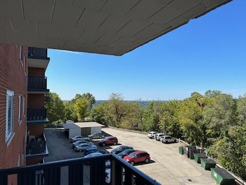 A balcony overlooking a parking lot with cars parked in it