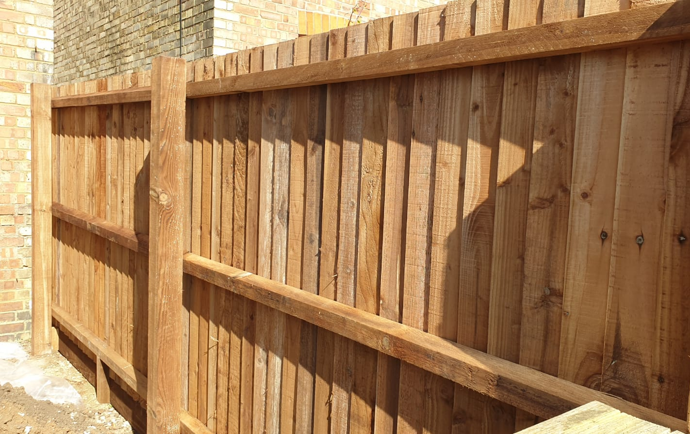 Finished feather edge wooden fence as seen from the frame side.