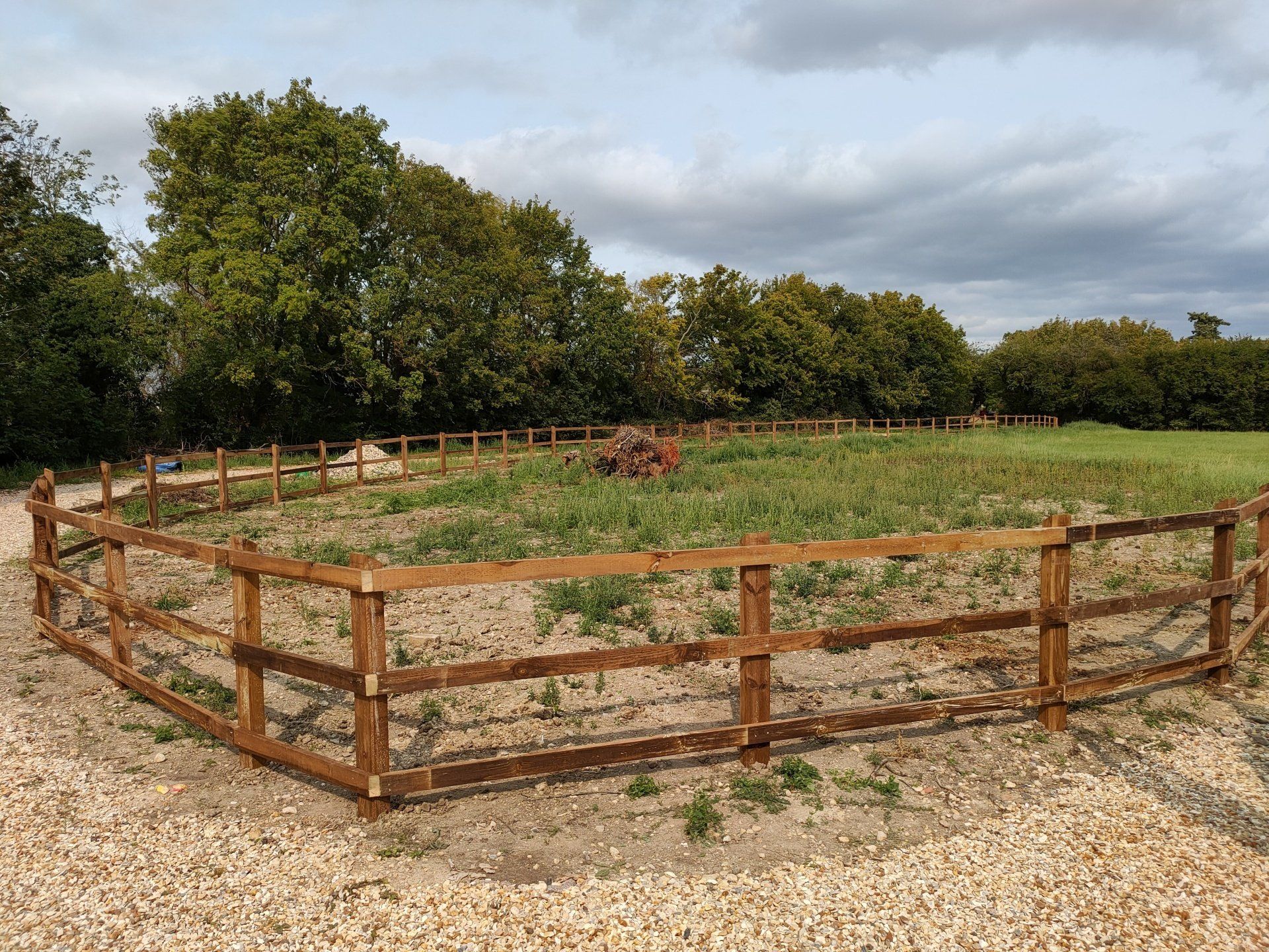 3 rail field fence with corners going towards a field gate.