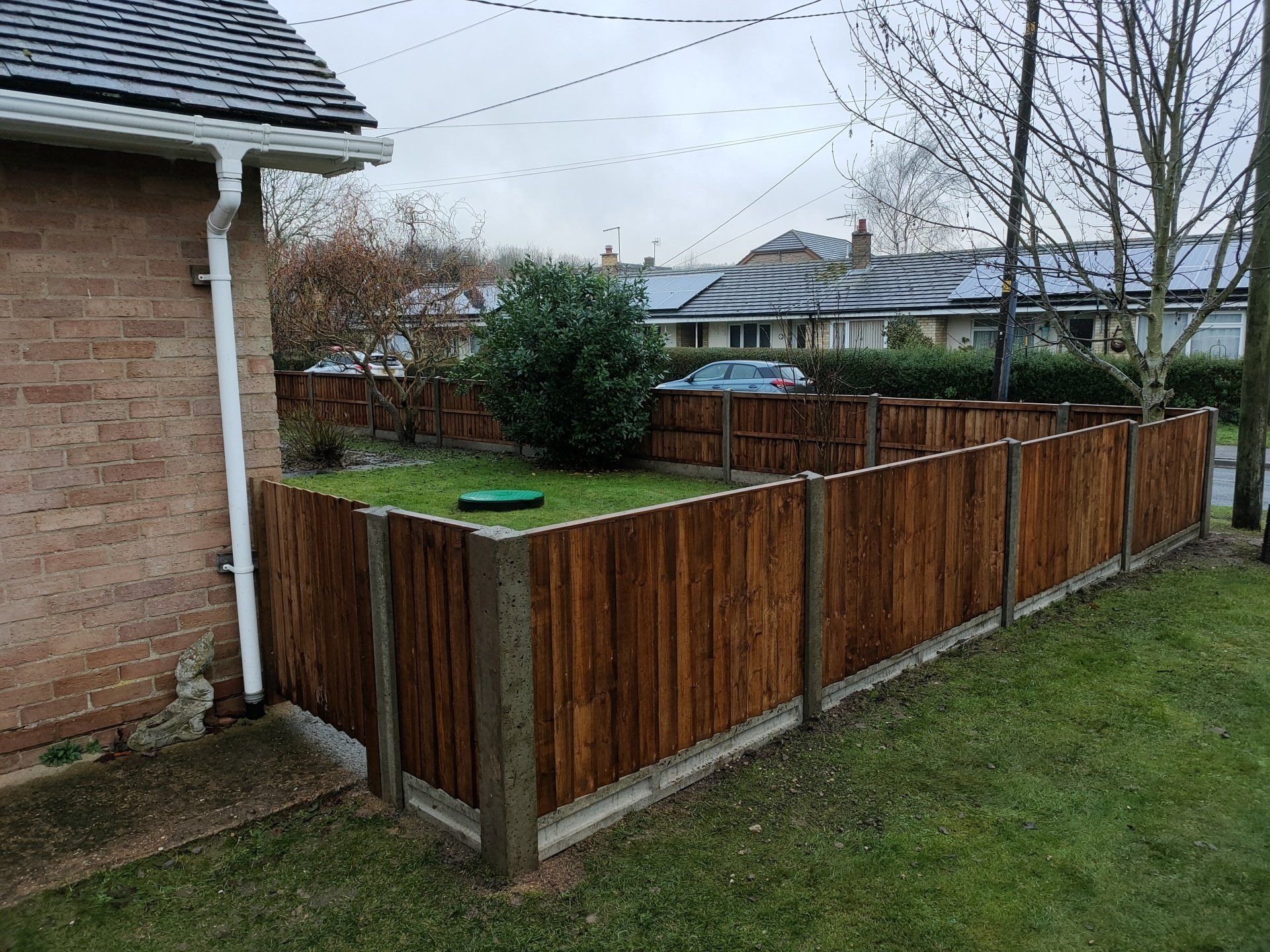 A short concrete posted and gravel board fence with panels