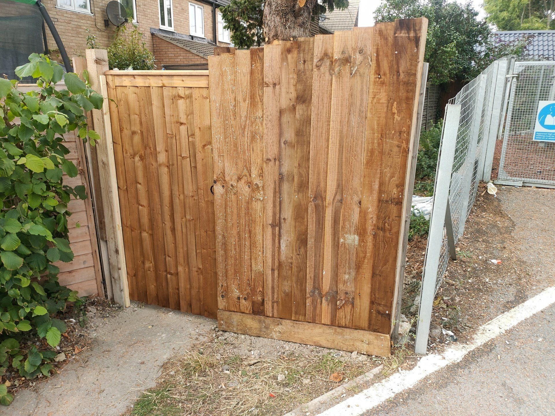 Very narrow inclined wooden feather edge fence and wooden single gate