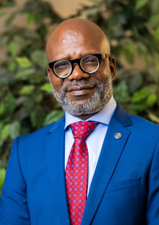 A man in a suit and tie is wearing glasses.