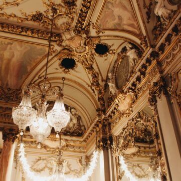 a very ornate room with a chandelier hanging from the ceiling .