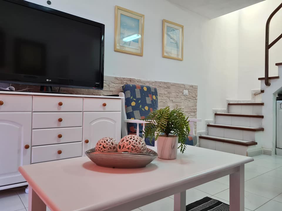 Ein Wohnzimmer mit einem weißen Couchtisch und einem Flachbildfernseher.