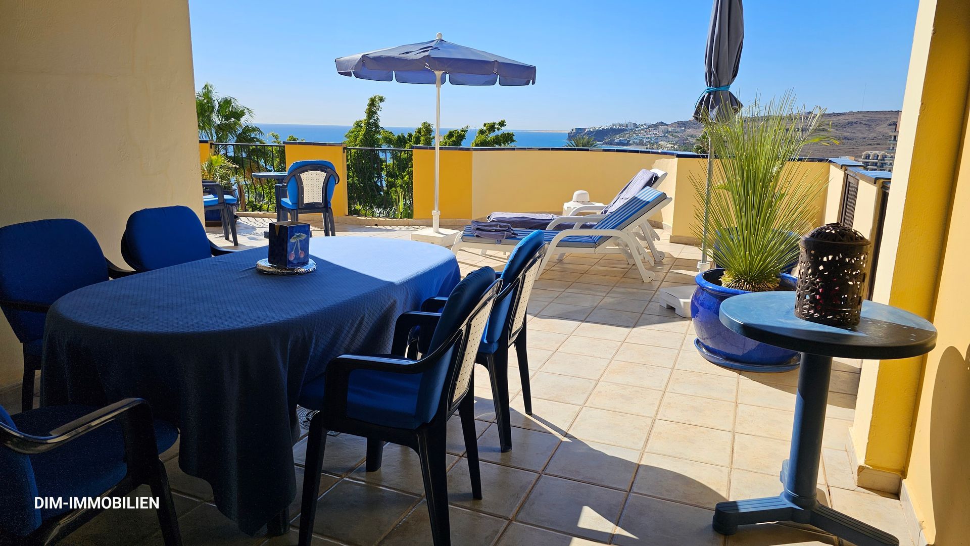 Ein Tisch und Stühle auf einem Balkon mit Blick auf das Meer