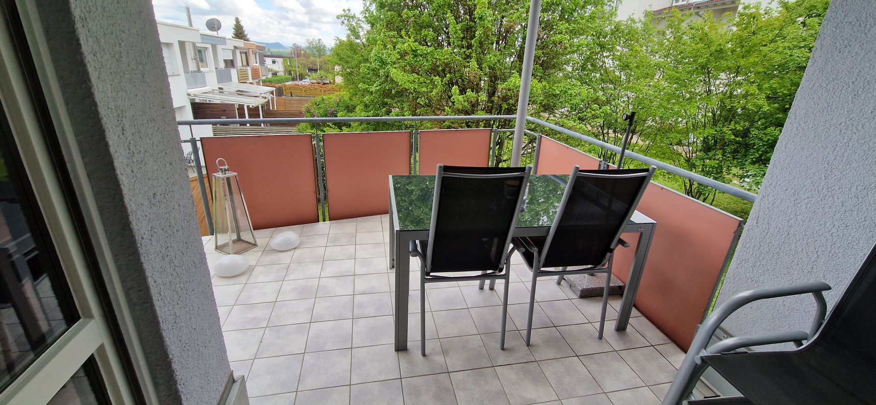 Ein Balkon mit einem Tisch und Stühlen.