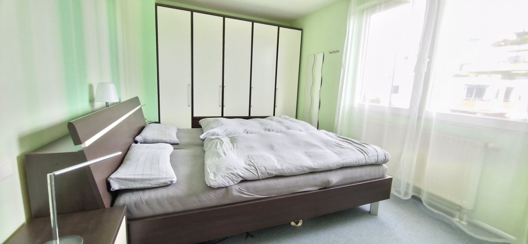 Ein Schlafzimmer mit großem Bett und Fenster.