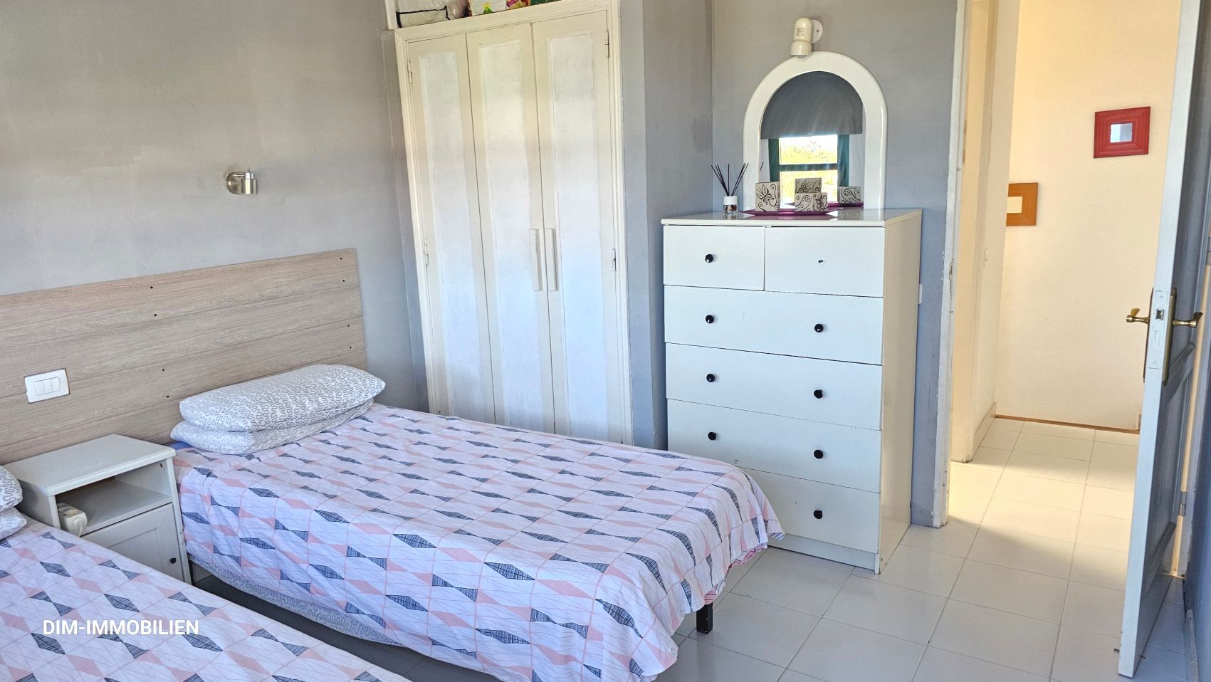 Ein Schlafzimmer mit zwei Betten, einer Kommode und einem Spiegel