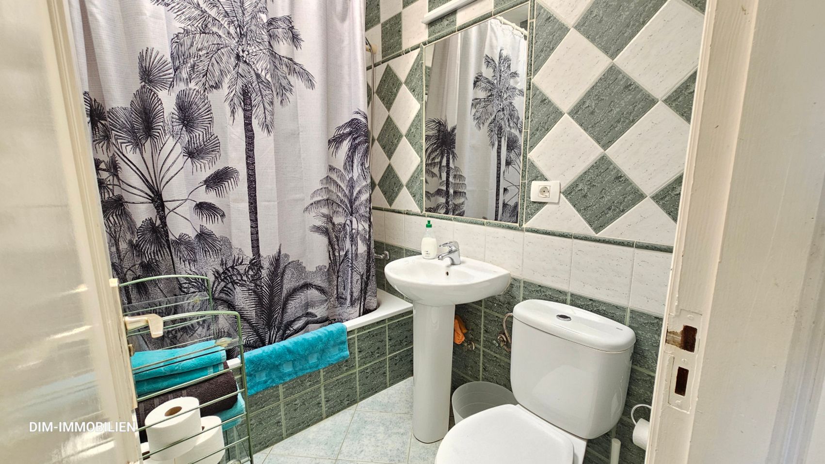 Ein Badezimmer mit Toilette, Waschbecken und Duschvorhang.