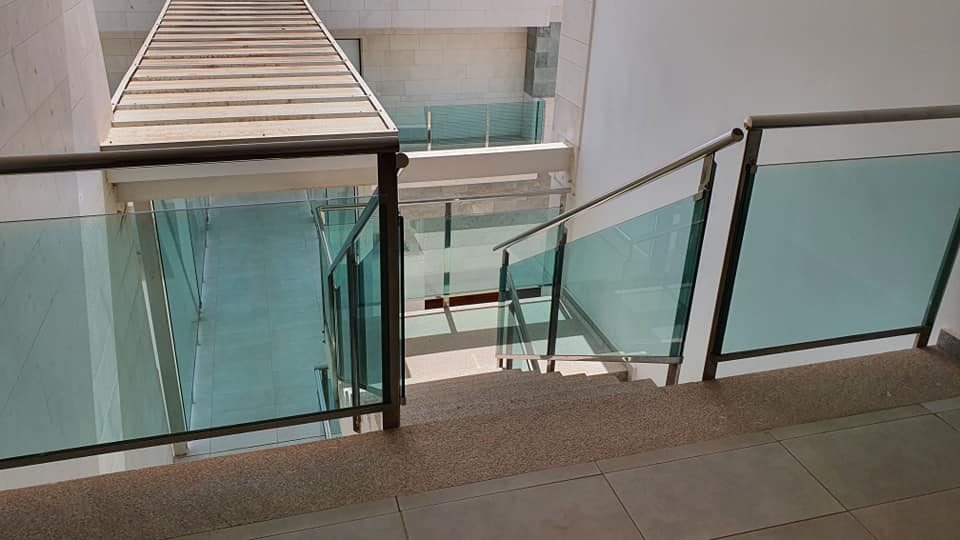 Eine Treppe mit Glasgeländer führt in den zweiten Stock.