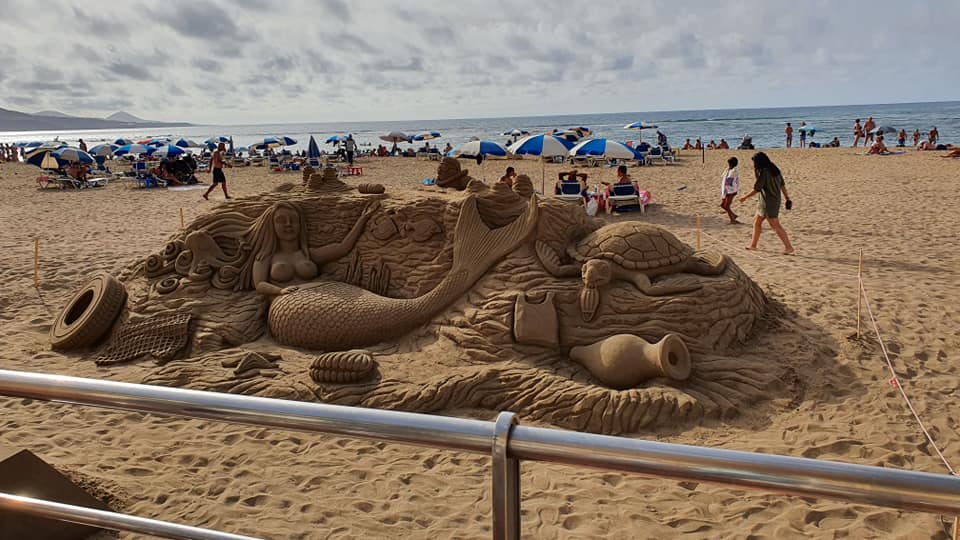 Am Strand gibt es eine Sandskulptur einer Meerjungfrau.