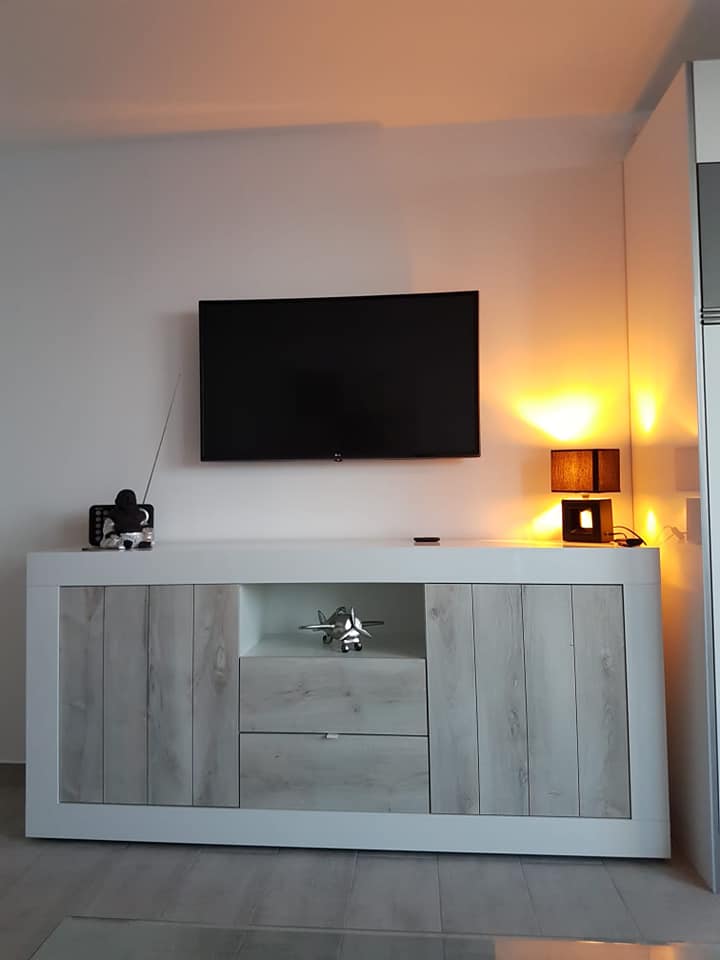 Ein Wohnzimmer mit einem Flachbildfernseher an der Wand