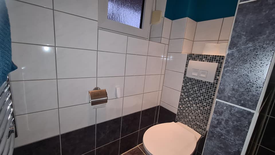 Ein Badezimmer mit schwarz-weißen Fliesen und einer Toilette