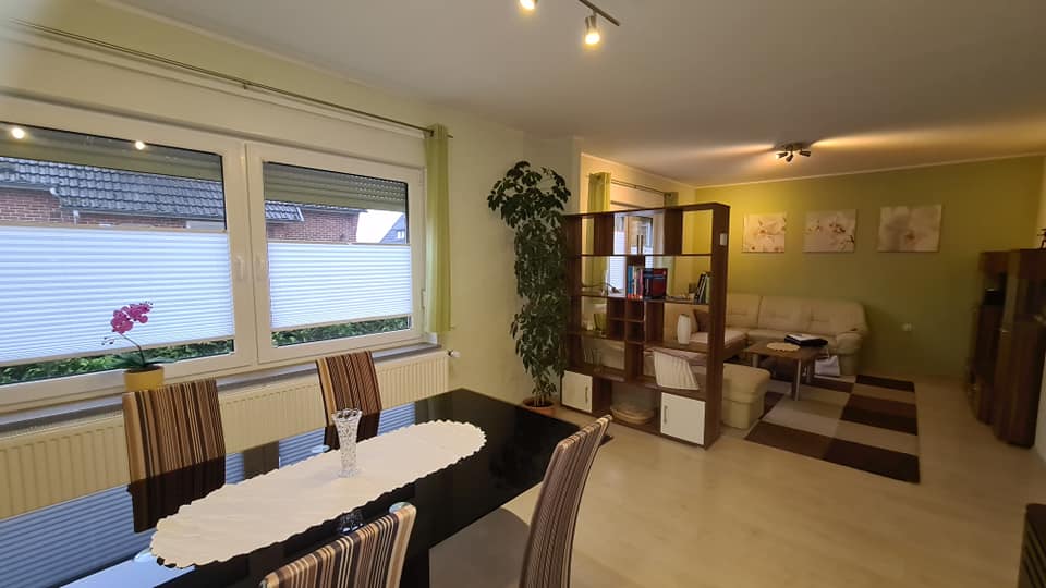 Ein Wohnzimmer mit einem Esstisch und Stühlen und einer Couch.