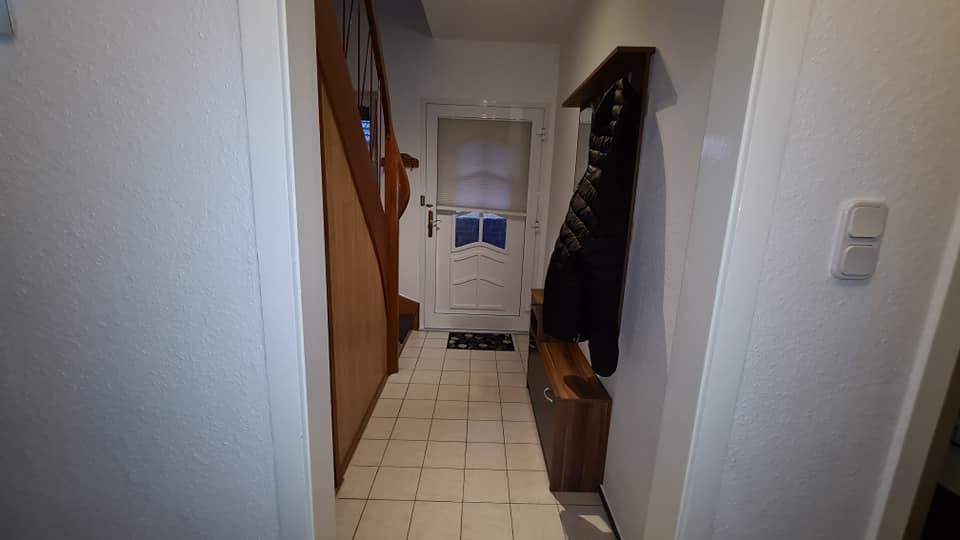 Ein Flur mit einer Garderobe und einer Treppe im Hintergrund.