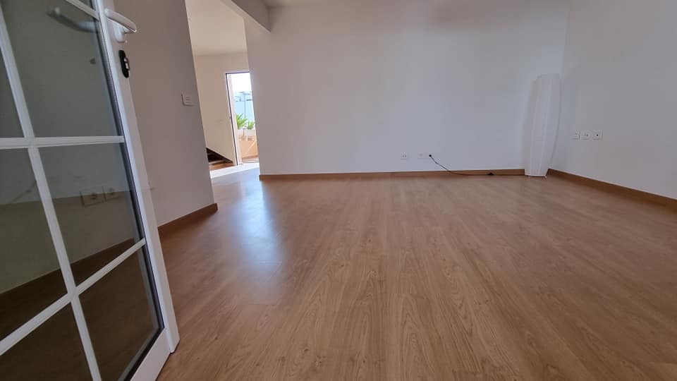 Ein leerer Raum mit Holzboden und weißen Wänden