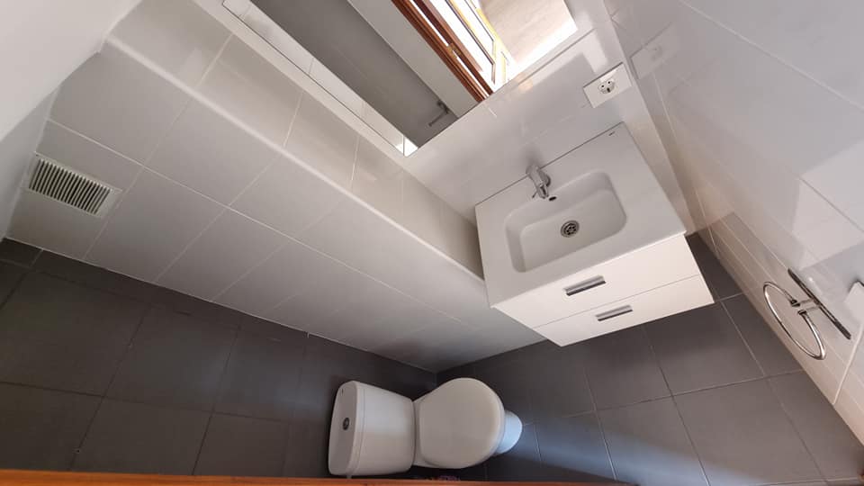 Ein Badezimmer mit Toilette, Waschbecken und Spiegel.