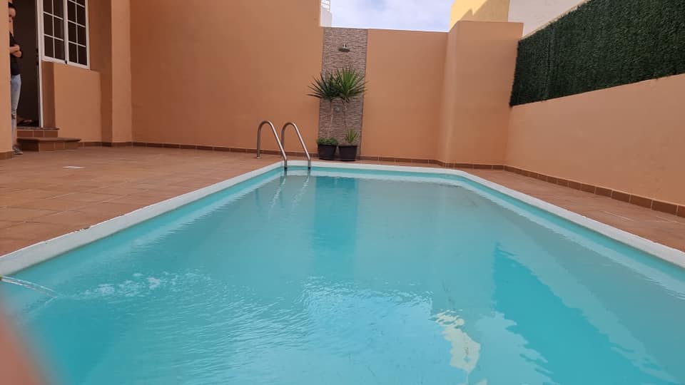 Im Hinterhof eines Hauses befindet sich ein Swimmingpool.