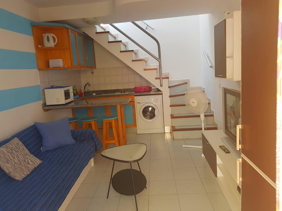 Ein Wohnzimmer mit einer Couch, einem Tisch und einer Treppe