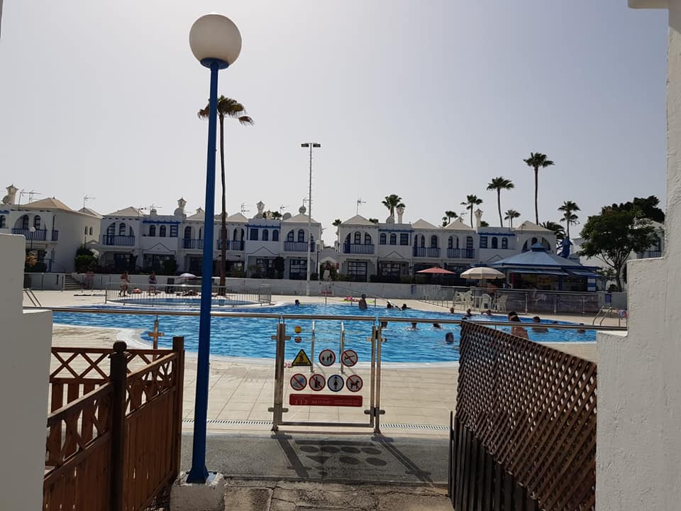 Ein Swimmingpool ist von einem Zaun und einem Laternenpfahl umgeben.
