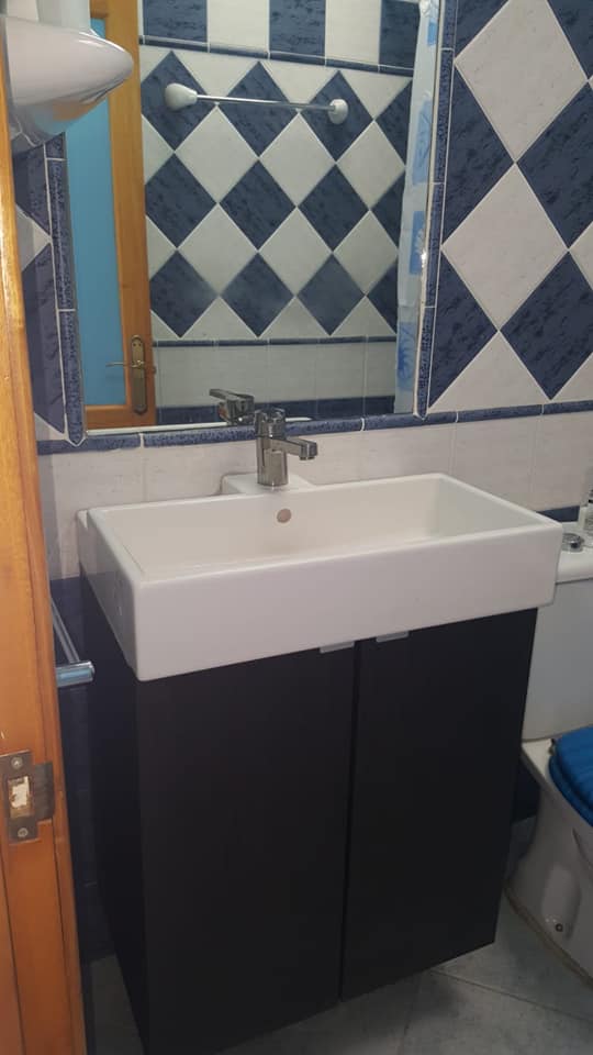 Ein Badezimmer mit Waschbecken, Spiegel und Toilette.