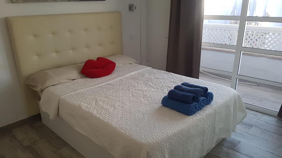 Ein Bett mit einer weißen Decke und blauen Handtüchern darauf in einem Schlafzimmer.
