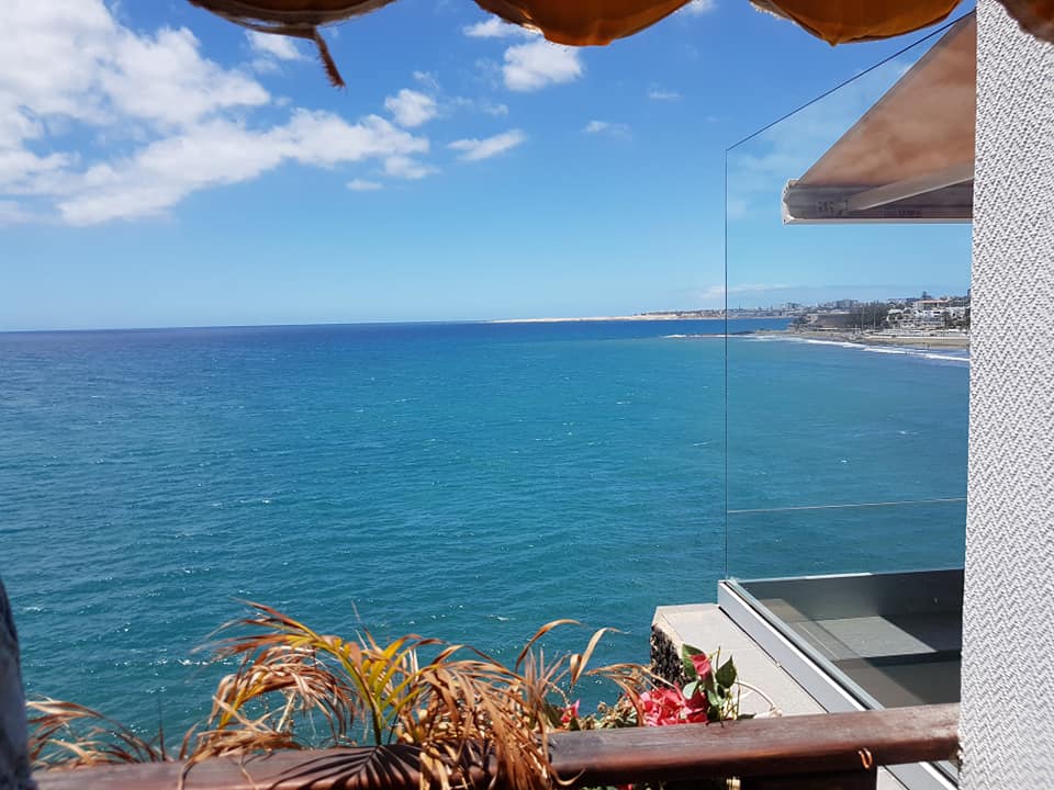 Blick auf das Meer von einem Balkon mit Glasgeländer