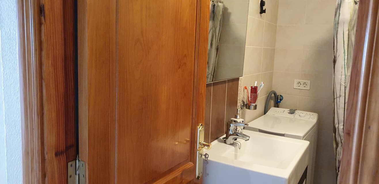 Ein Badezimmer mit Waschbecken, Waschmaschine und Spiegel.