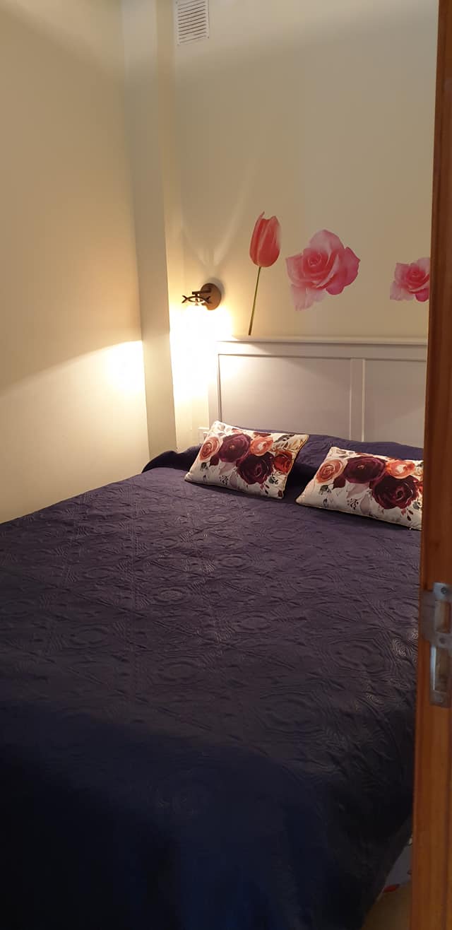 Ein Schlafzimmer mit einem Bett und Blumen an der Wand