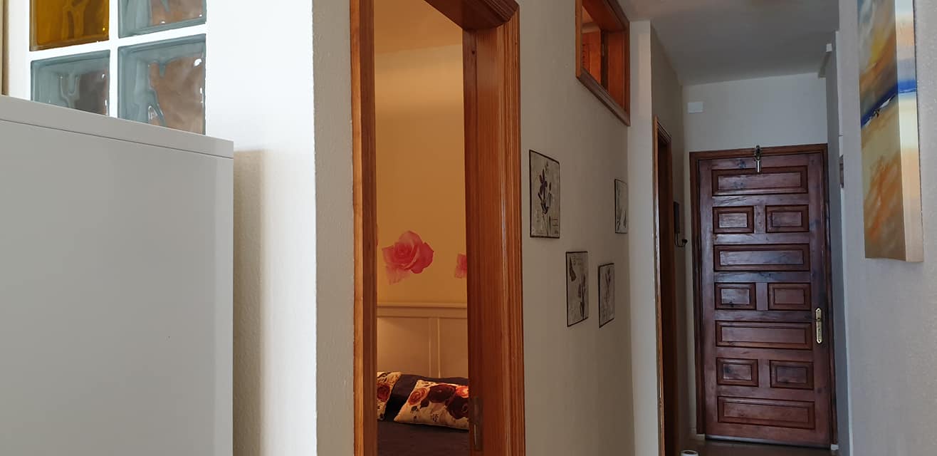 Ein Flur mit einer Holztür, die zu einem Schlafzimmer führt.