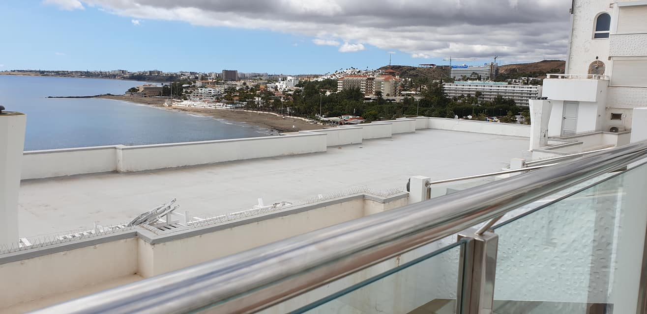 Ein Balkon mit Blick auf das Meer und die Stadt.