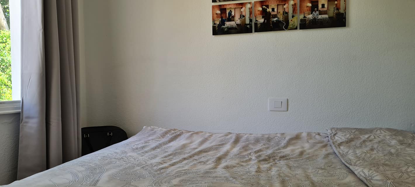 Ein Bett in einem Schlafzimmer mit einem Gemälde an der Wand darüber.