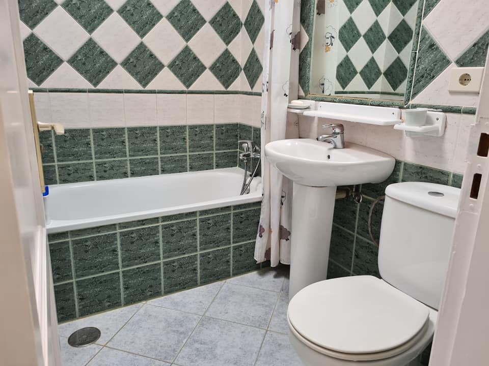 Ein Badezimmer mit Toilette, Waschbecken und Badewanne