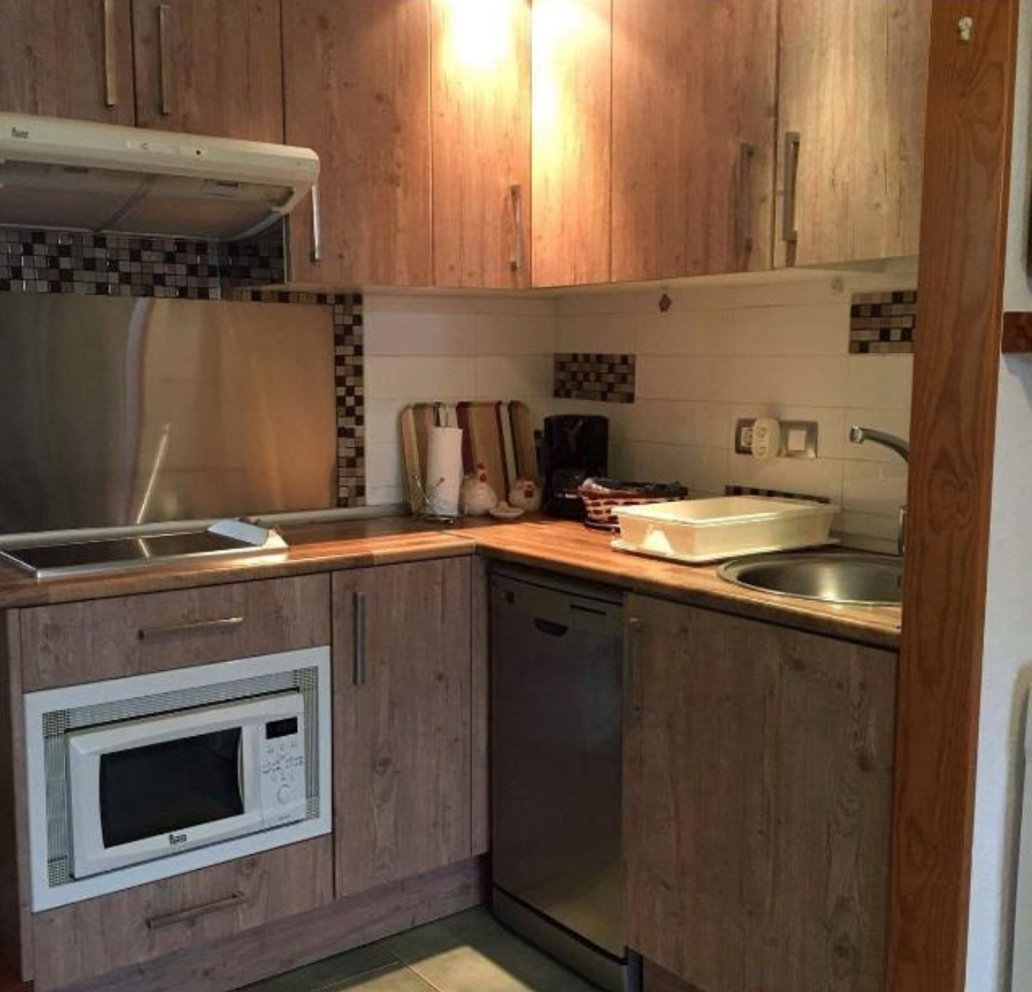Eine Küche mit Holzschränken und Geräten aus Edelstahl