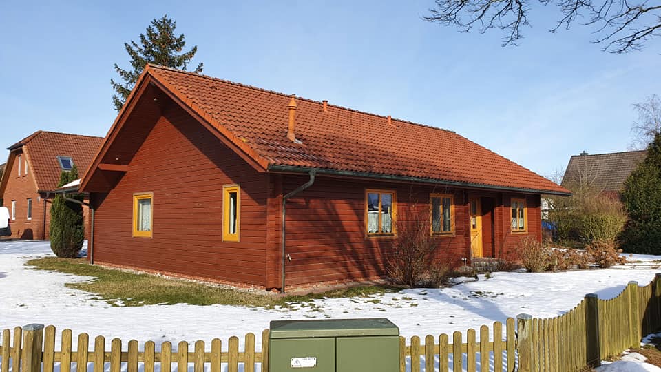 Ein rotes Haus mit einem grünen Kasten davor