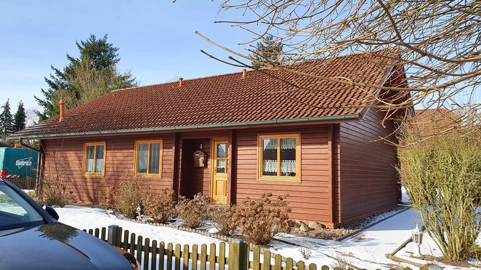 Ein kleines Holzhaus mit einem davor geparkten Auto.