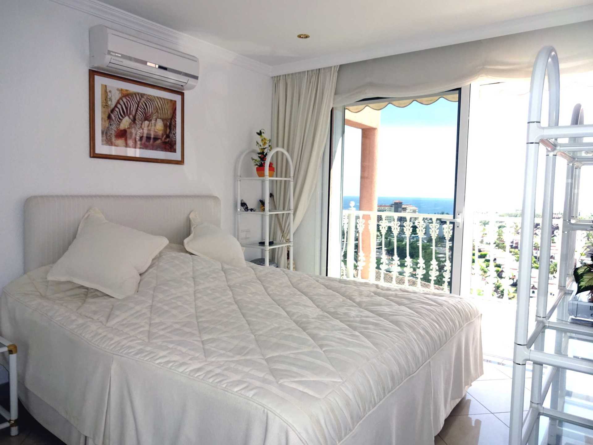 Ein Schlafzimmer mit großem Bett und Balkon