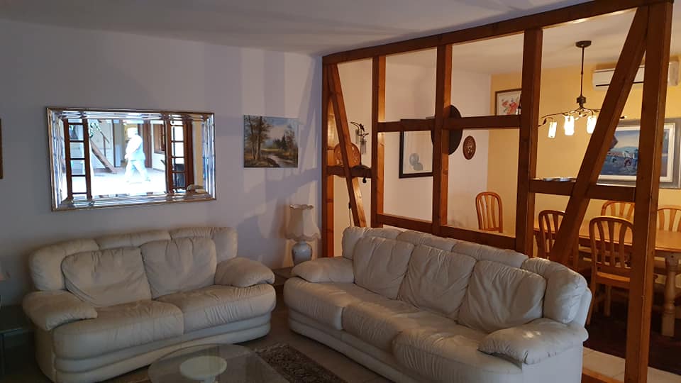 Ein Wohnzimmer mit zwei weißen Sofas und einem Esszimmer im Hintergrund