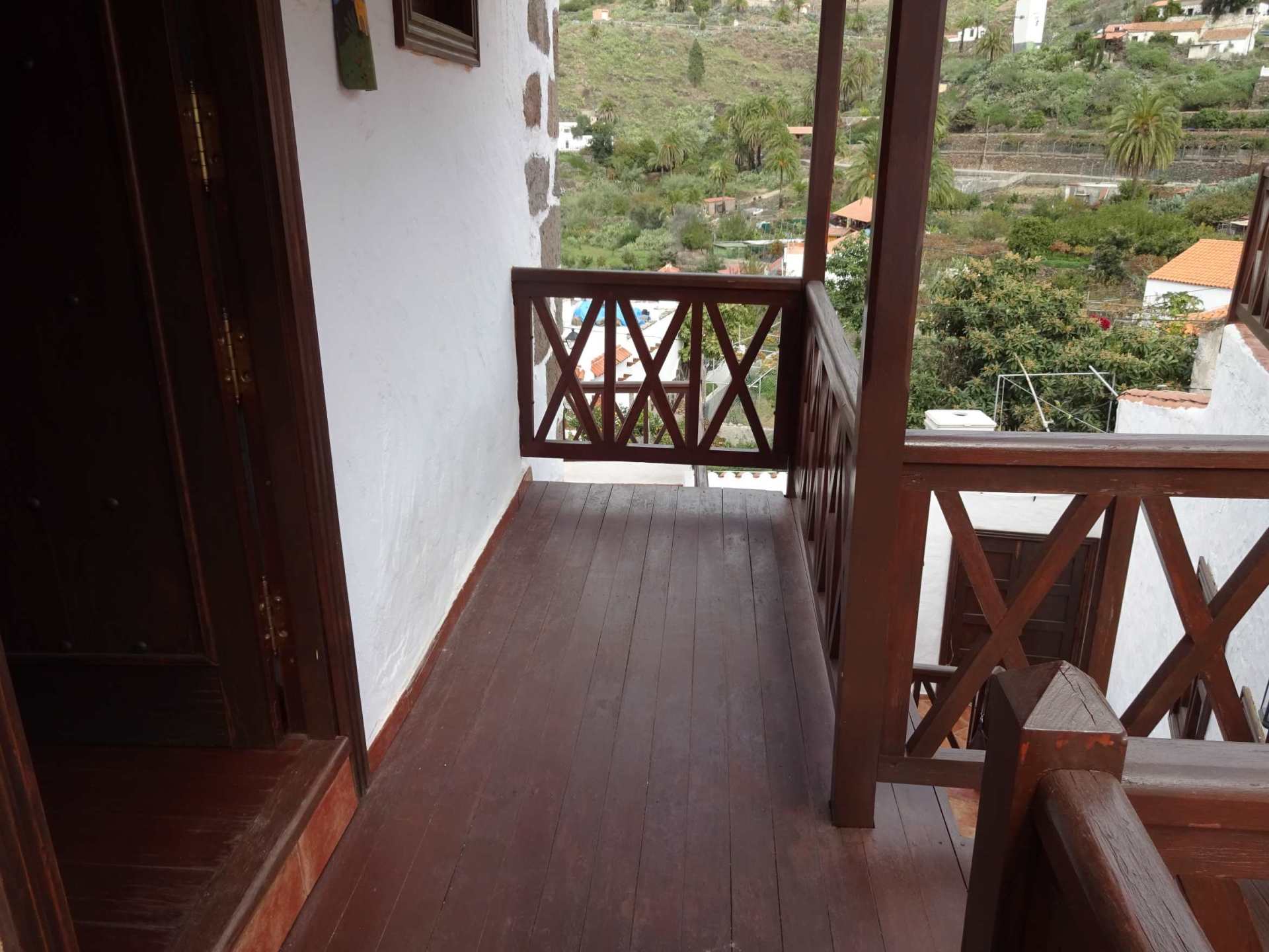 Ein Balkon mit Holzgeländer und Treppe, die dorthin führt