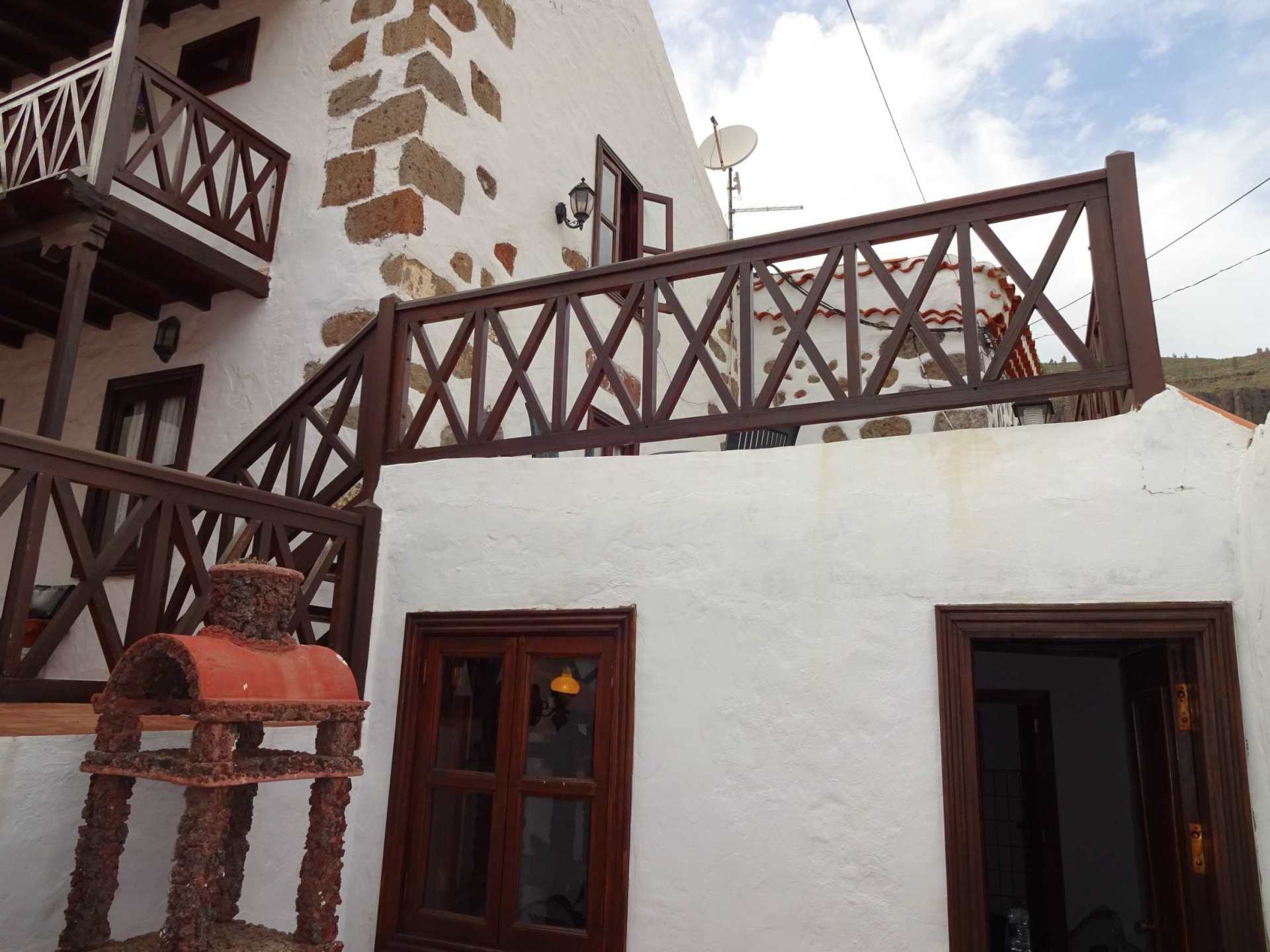 Ein weißes Gebäude mit einem Holzbalkon und Treppen
