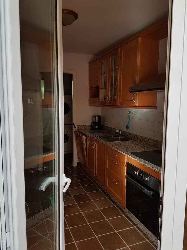 Eine Küche mit Holzschränken und einer Glasschiebetür