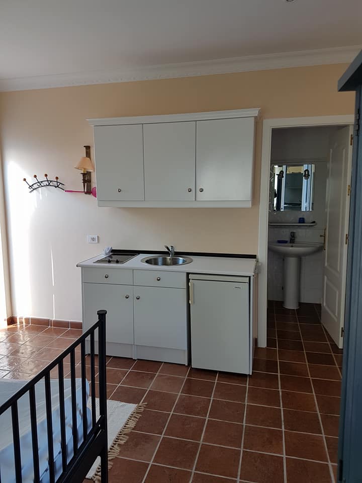Eine Küche mit Spüle, Kühlschrank und Schränken