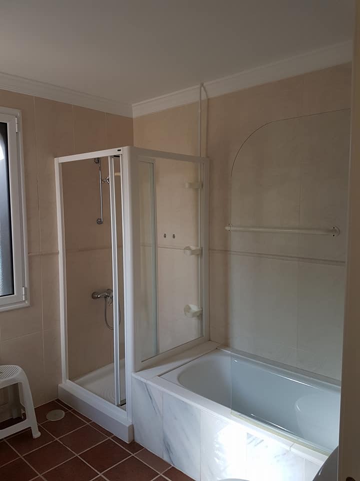 Ein Badezimmer mit Badewanne und Duschkabine.