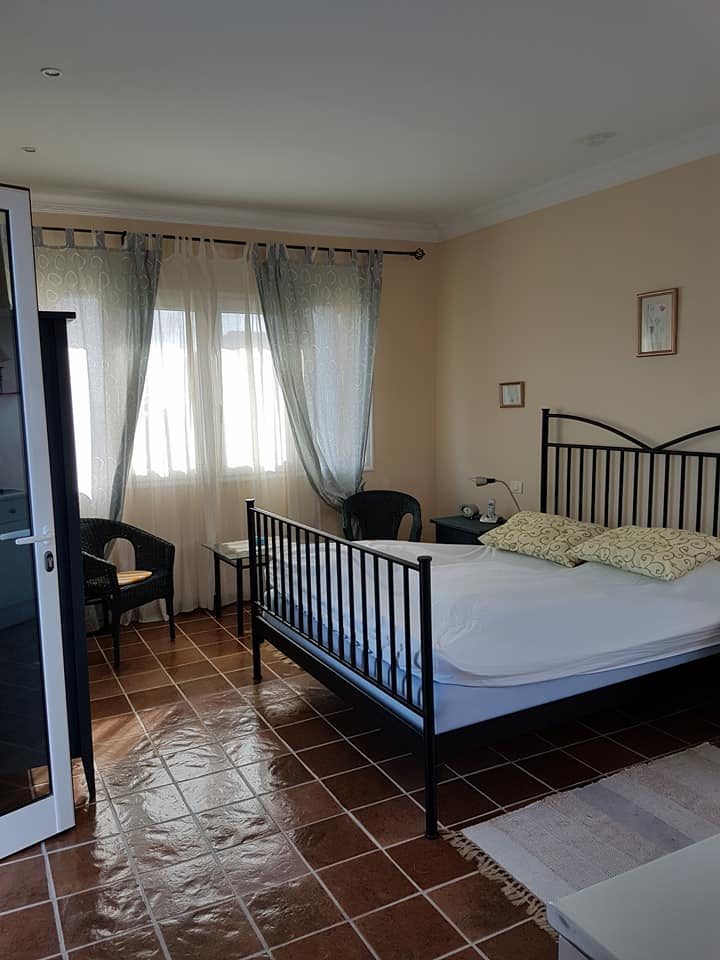 Ein Schlafzimmer mit einem großen Bett und einem Sessel